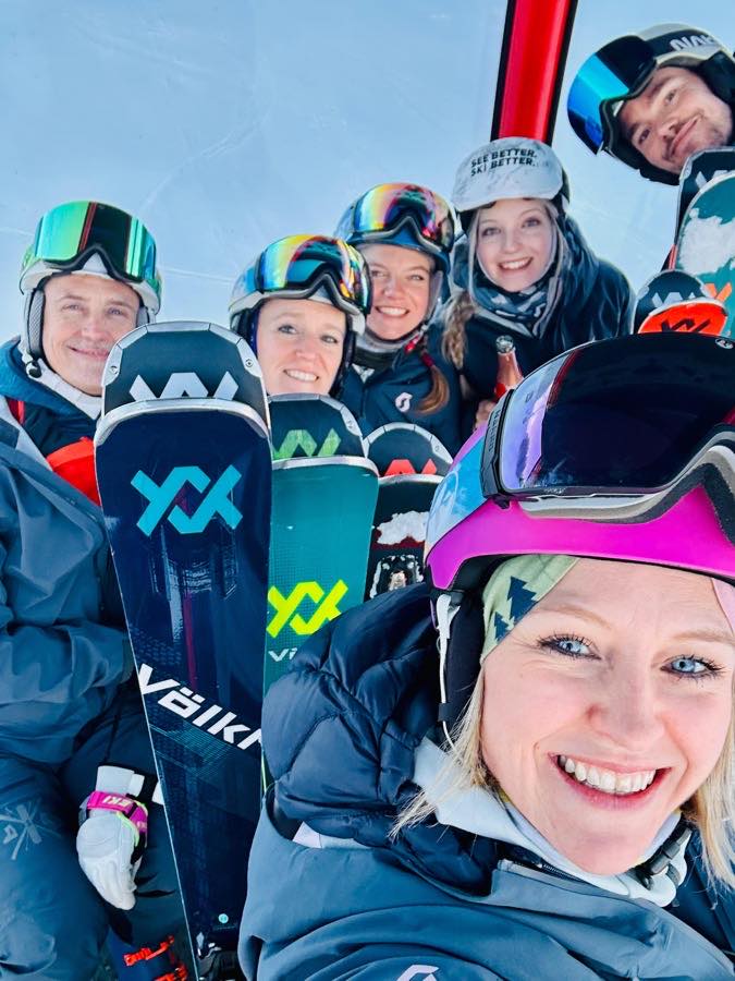 Gruppe dicht gedrängt in der Gondel, Ski und Board zwischen den Knien